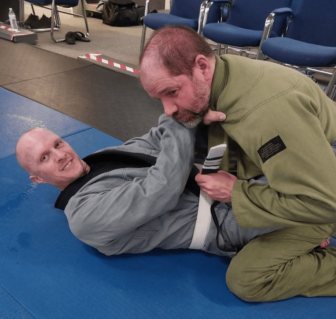 Two adult grapplers practicing a ground position